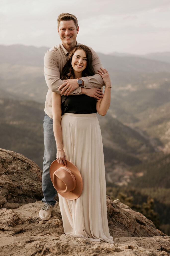 man wraps arms around womans shoulders at lost gulch during engagement photos.