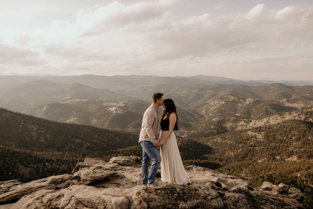 man kisses womans head during colorado engagement photos at lost gulch.