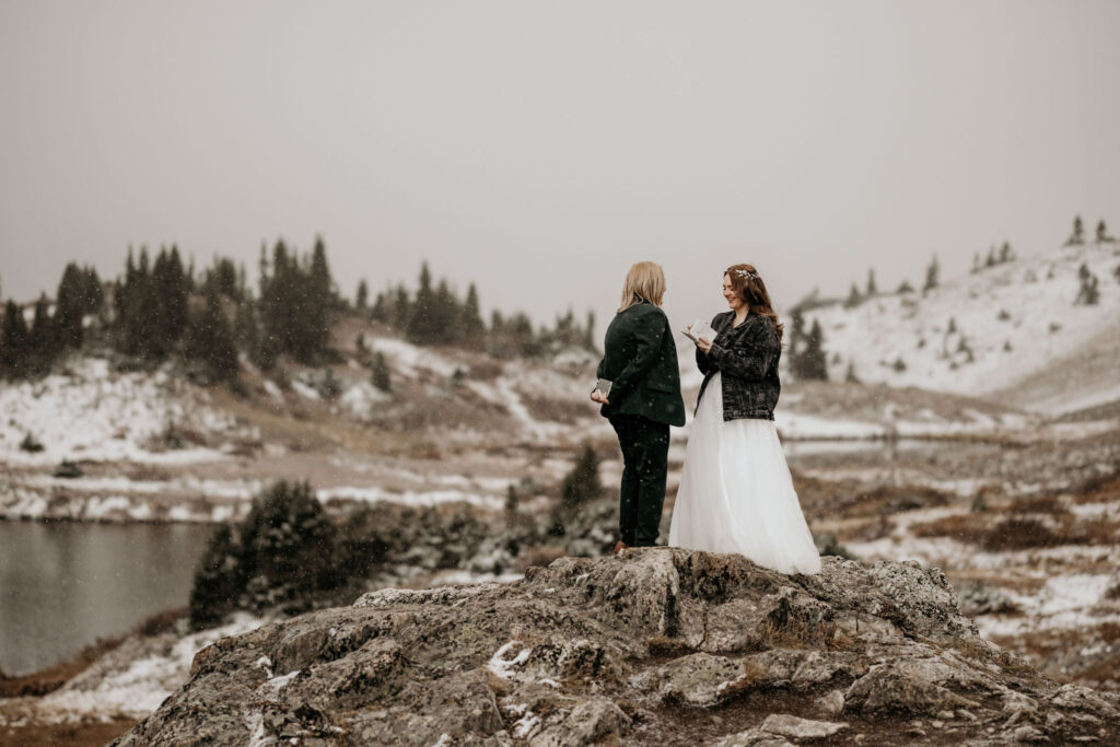 a couple stands on a rock and says self-written vows during colorado elopement ceremony.