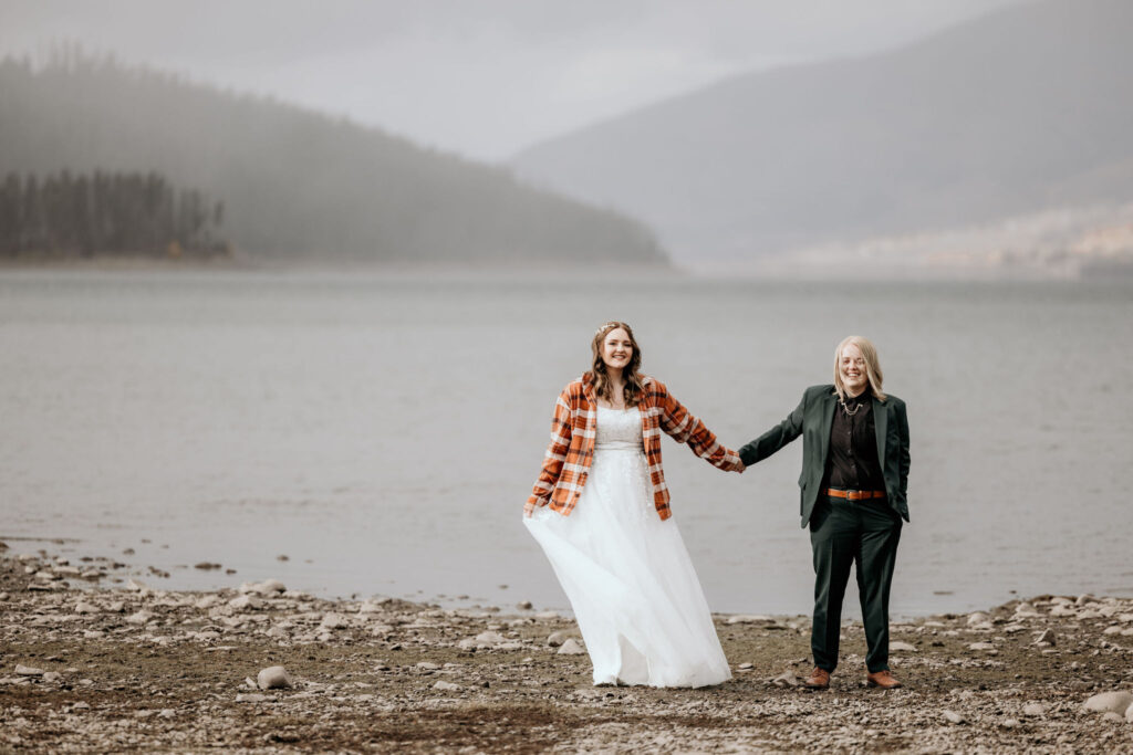 lgbtq+ couple hold hands during colorado elopement photos.