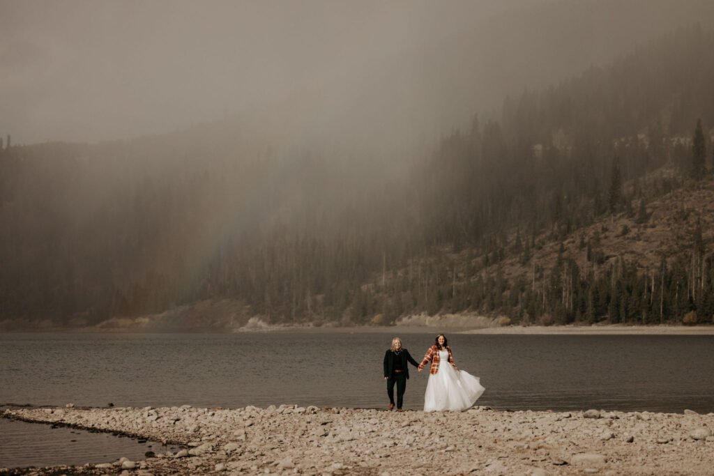LGBTQ+ couple walk along Lake Dillon during colorado couples portraits.