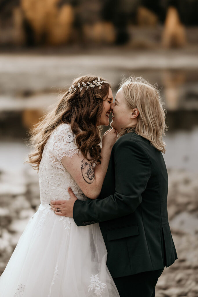 lgbtq+ couple kisses at lake dillon colorado on wedding day.