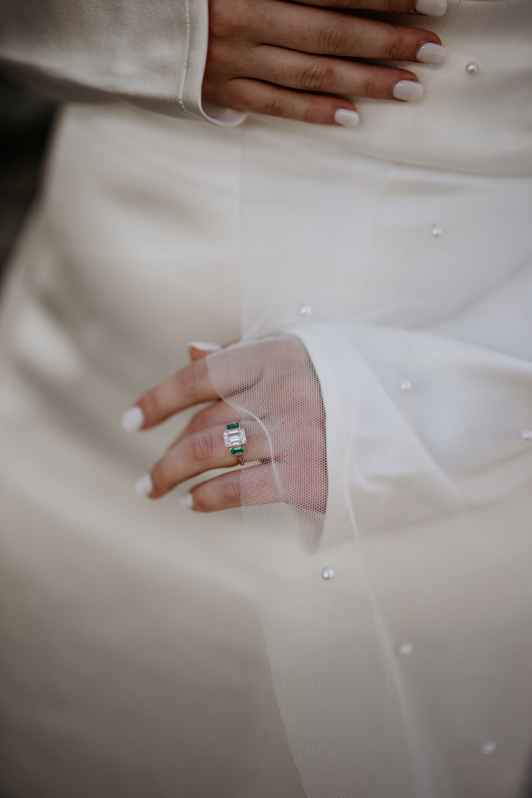 close up image of brides hand with engagement ring and veil.