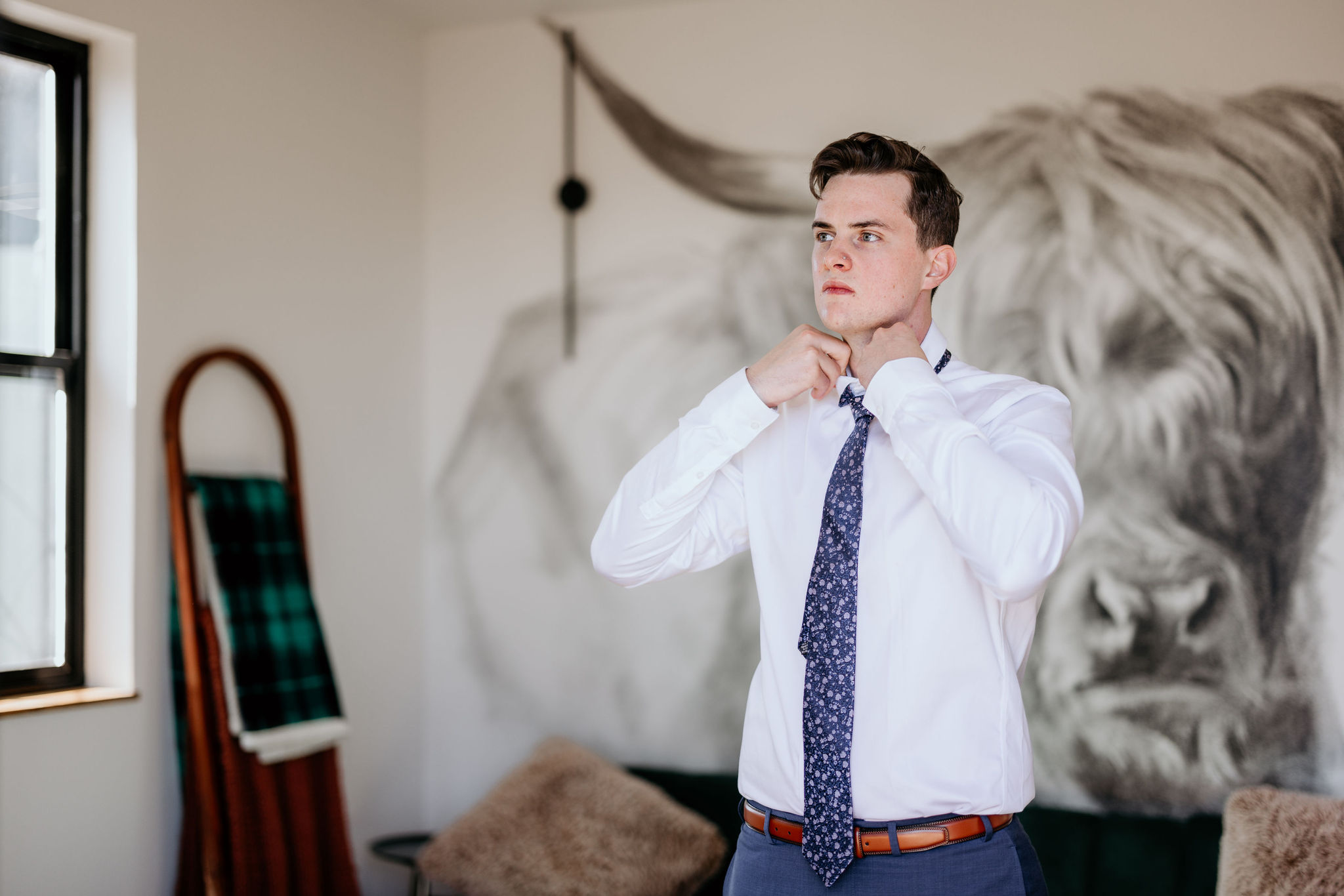 groom fixes tie in colorado airbnb before elopement.