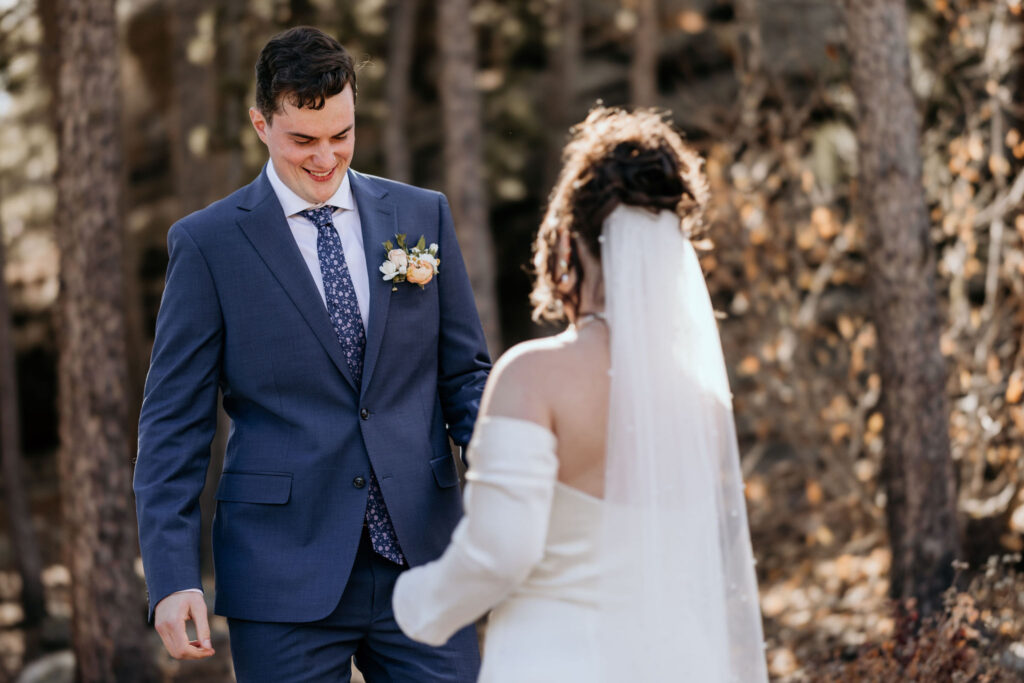 groom smiles at bride during wedding day first look photos.