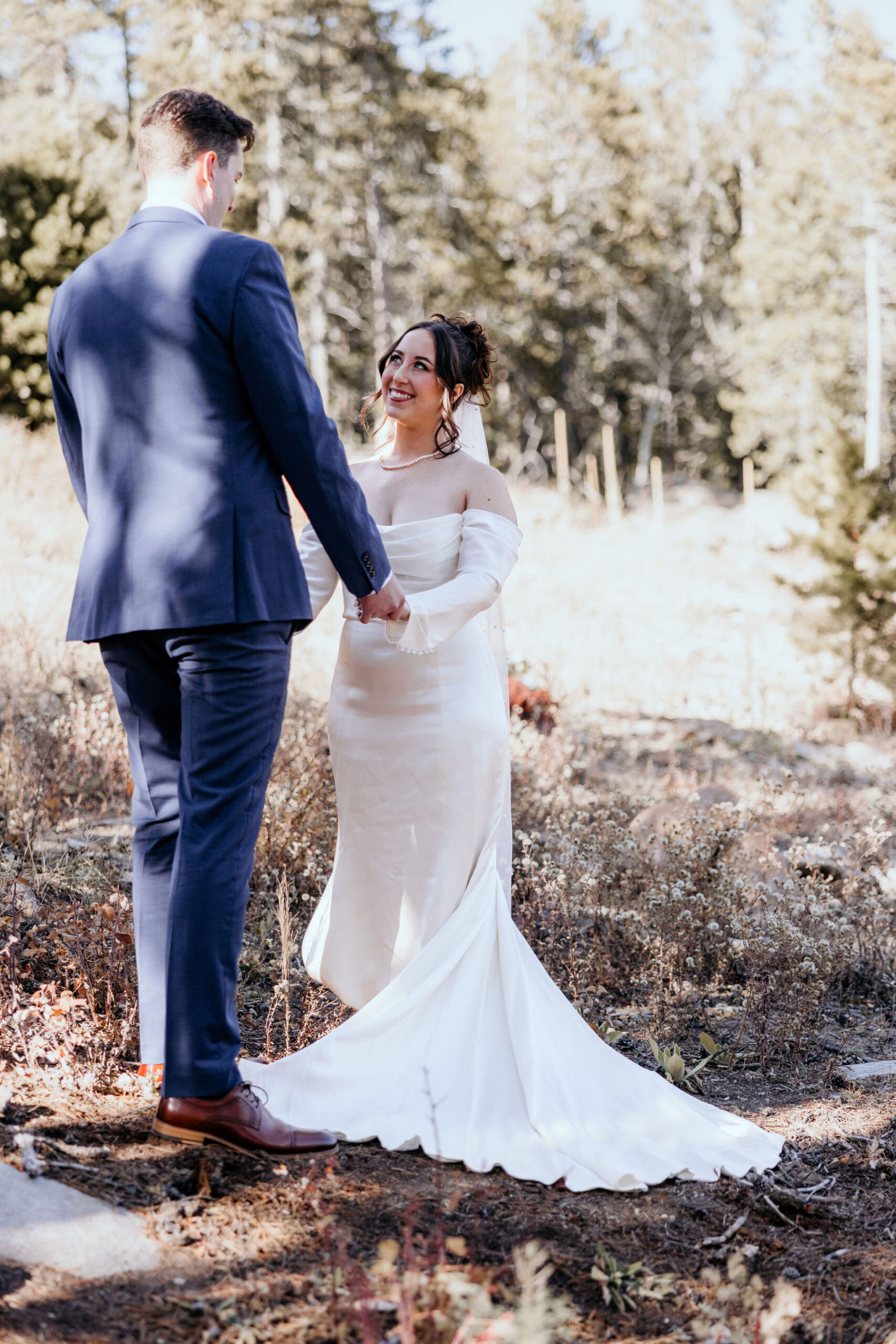 bride looks up and smiles at groom during airbnb elopement photos in the colorado mountains.
