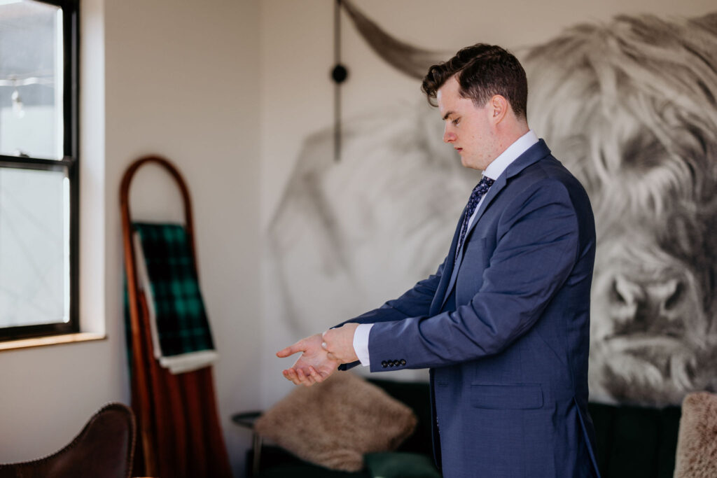 groom gets ready for his airbnb elopement.