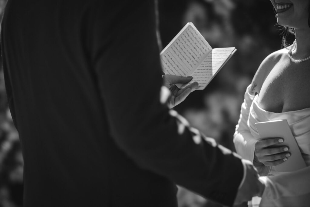 close up image of bride and groom holding wedding vow books.