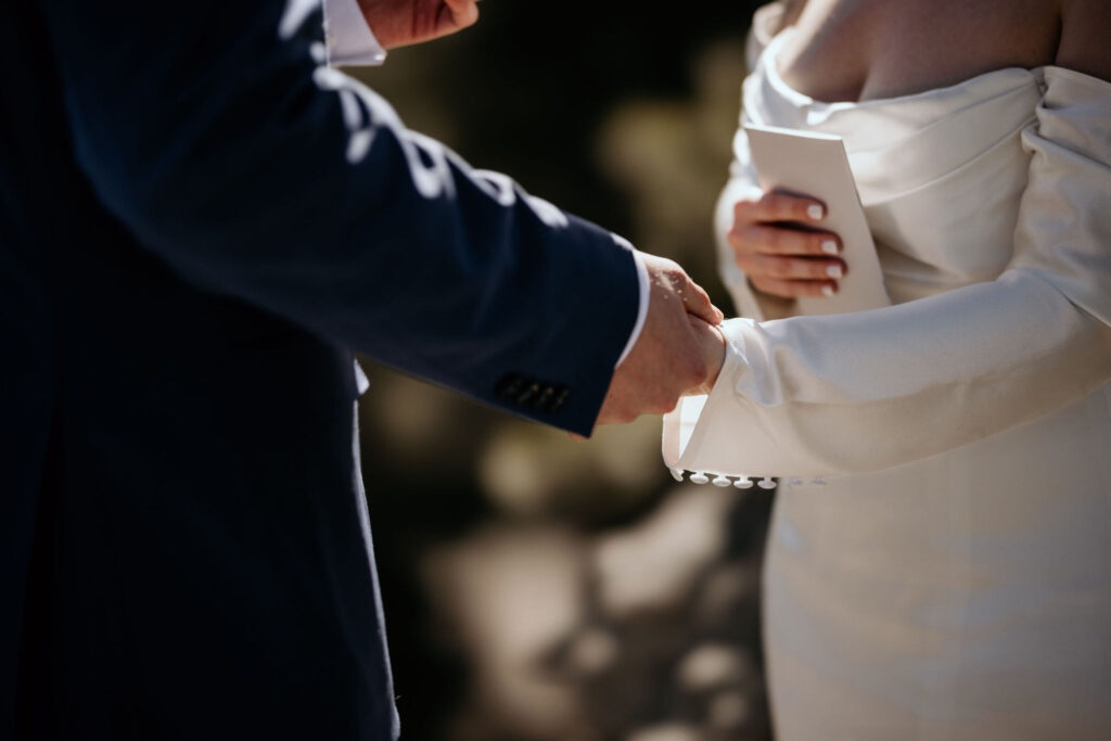 bride and groom hold hands during colorado elopement ceremony.