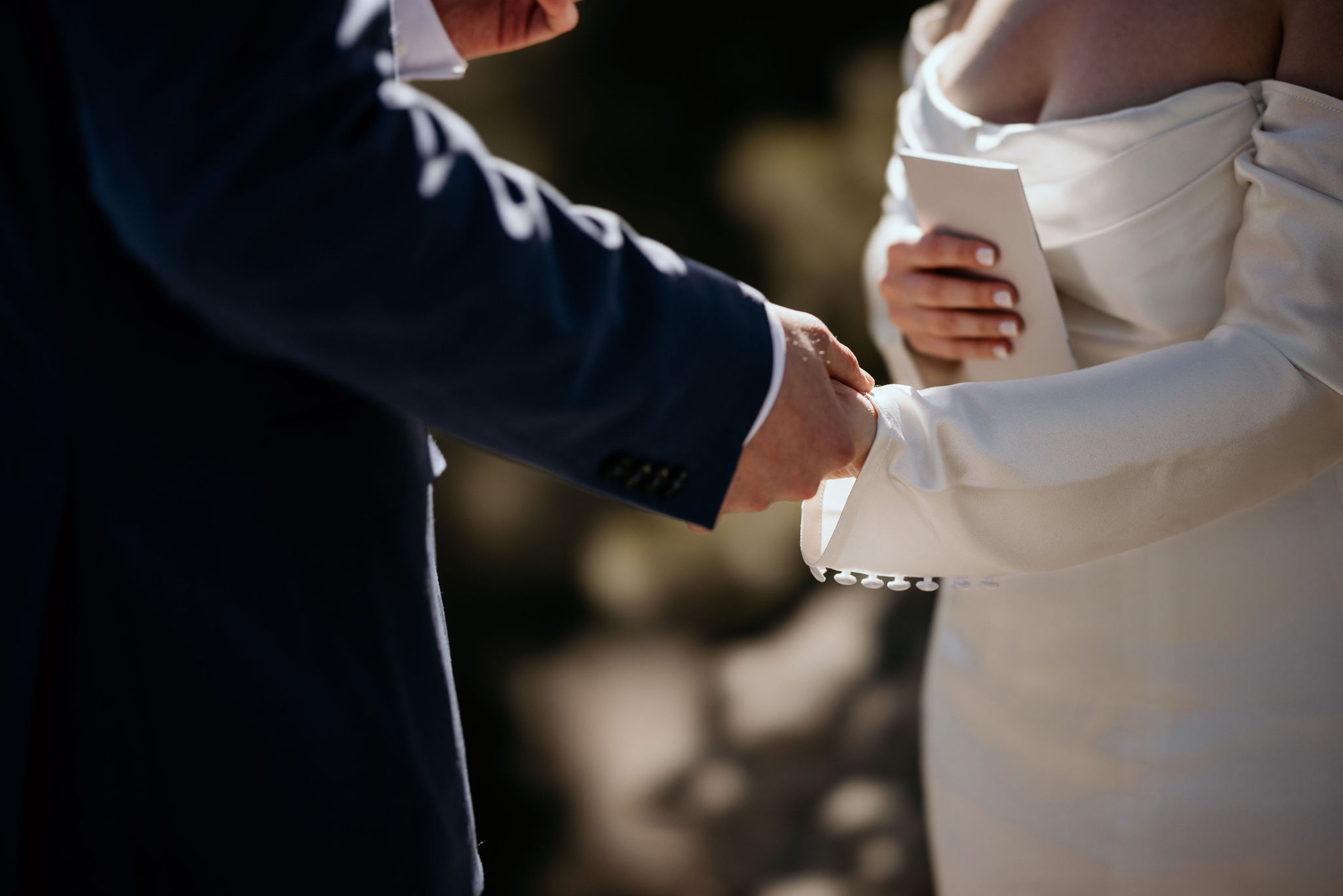 bride and groom hold hands during colorado airbnb elopement ceremony.