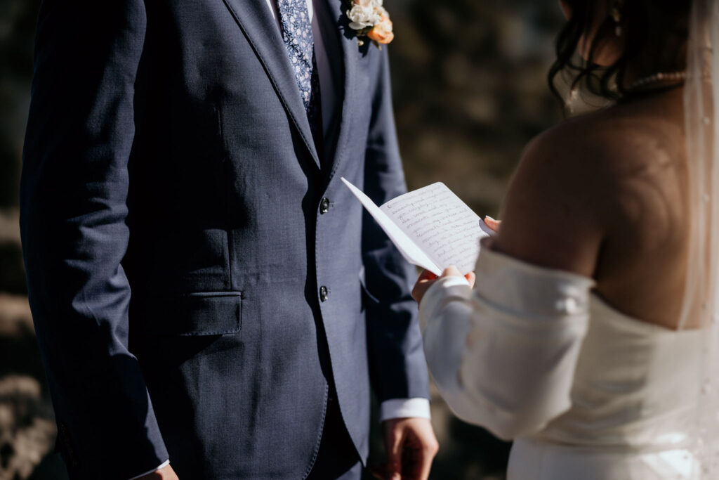 close up image of bride holding open wedding vow book.