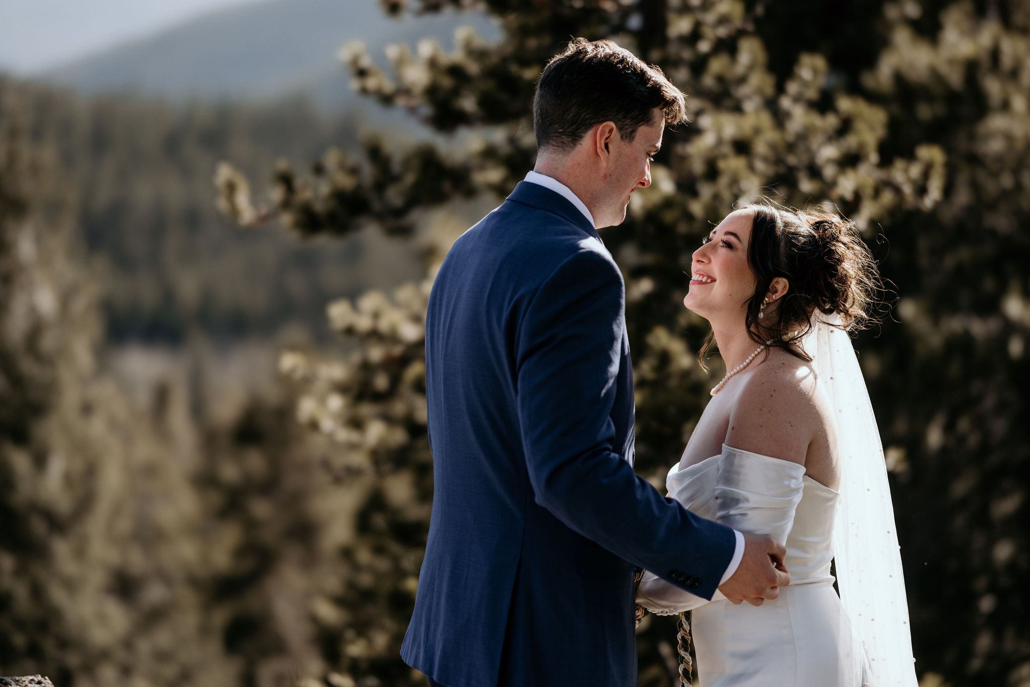 bride and groom smile at each other during their airbnb colorado elopement.