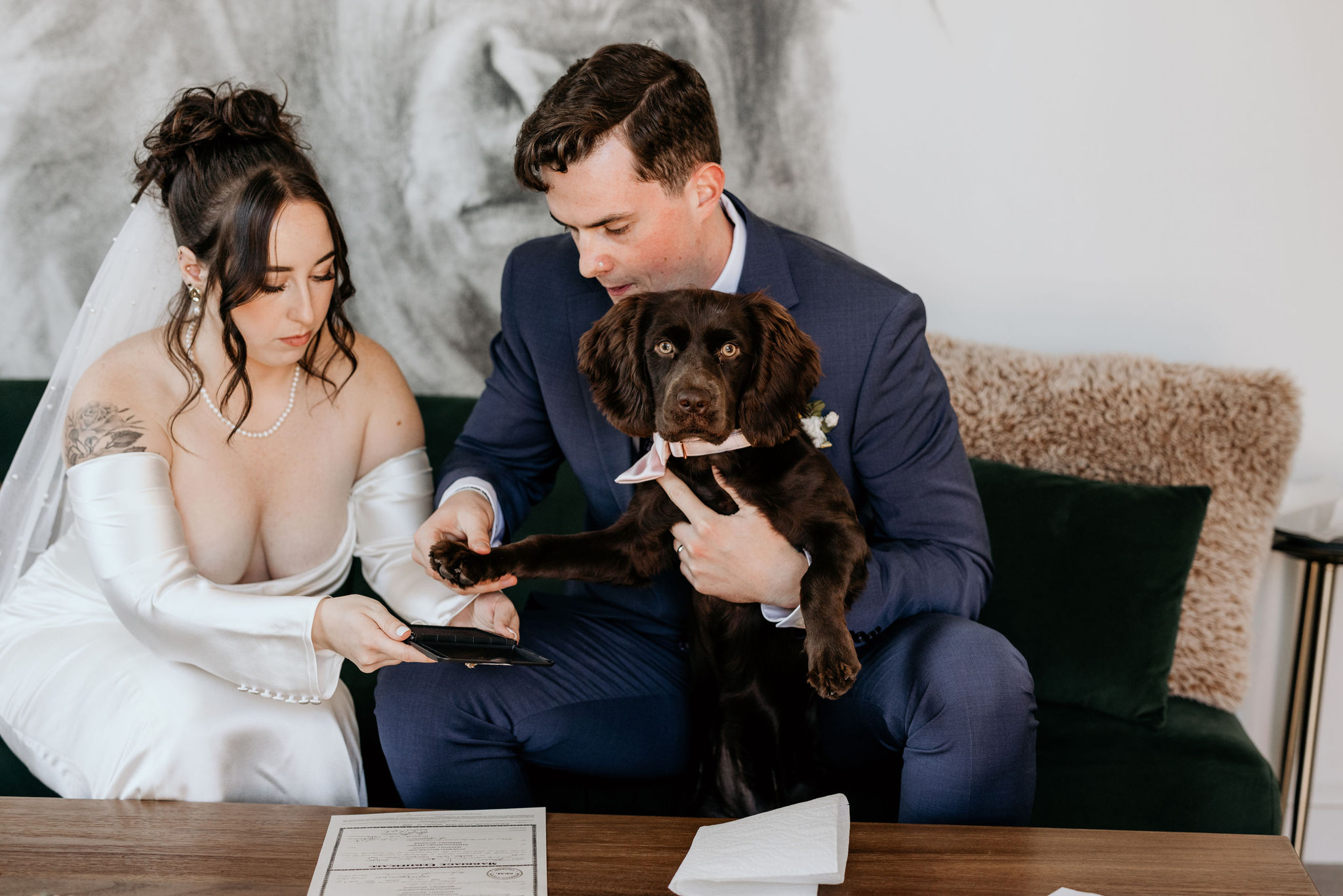 dog looks at camera as she is signing the marriage certificate.