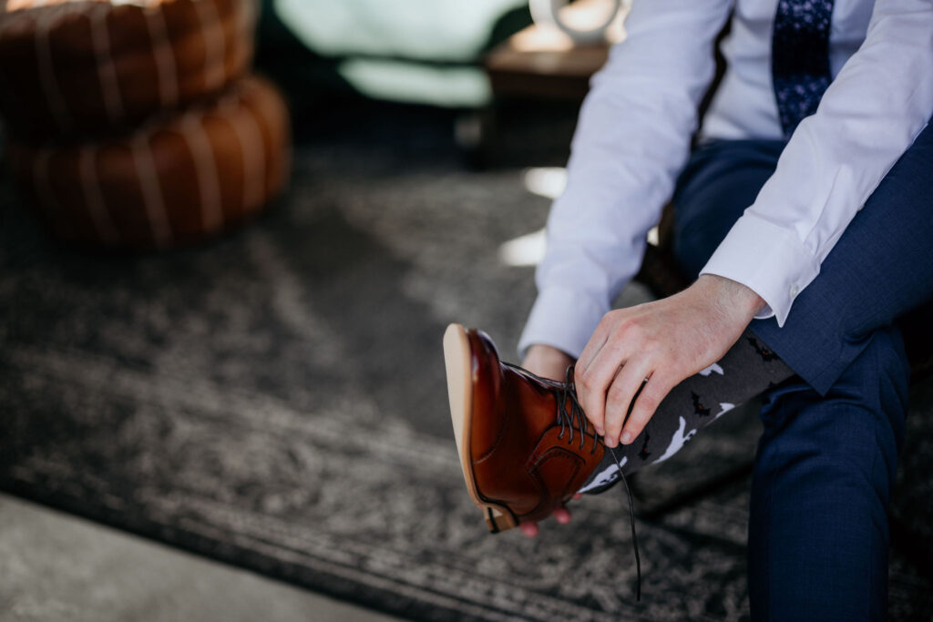close up image of groom putting on shoes during colorado elopement.