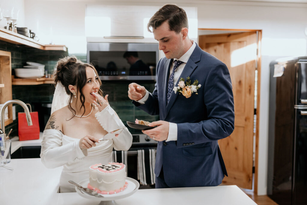 bride and groom cut their heart-shaped wedding cake in an airbnb.