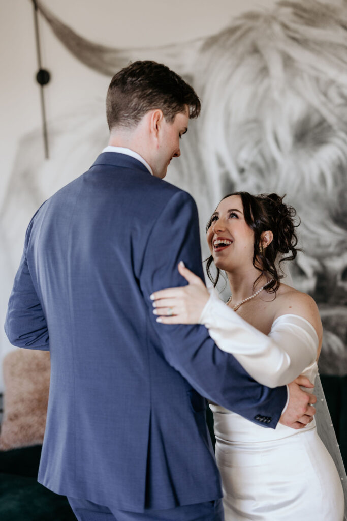 bride smiles at groom during elopement first dance at a colorado airbnb.