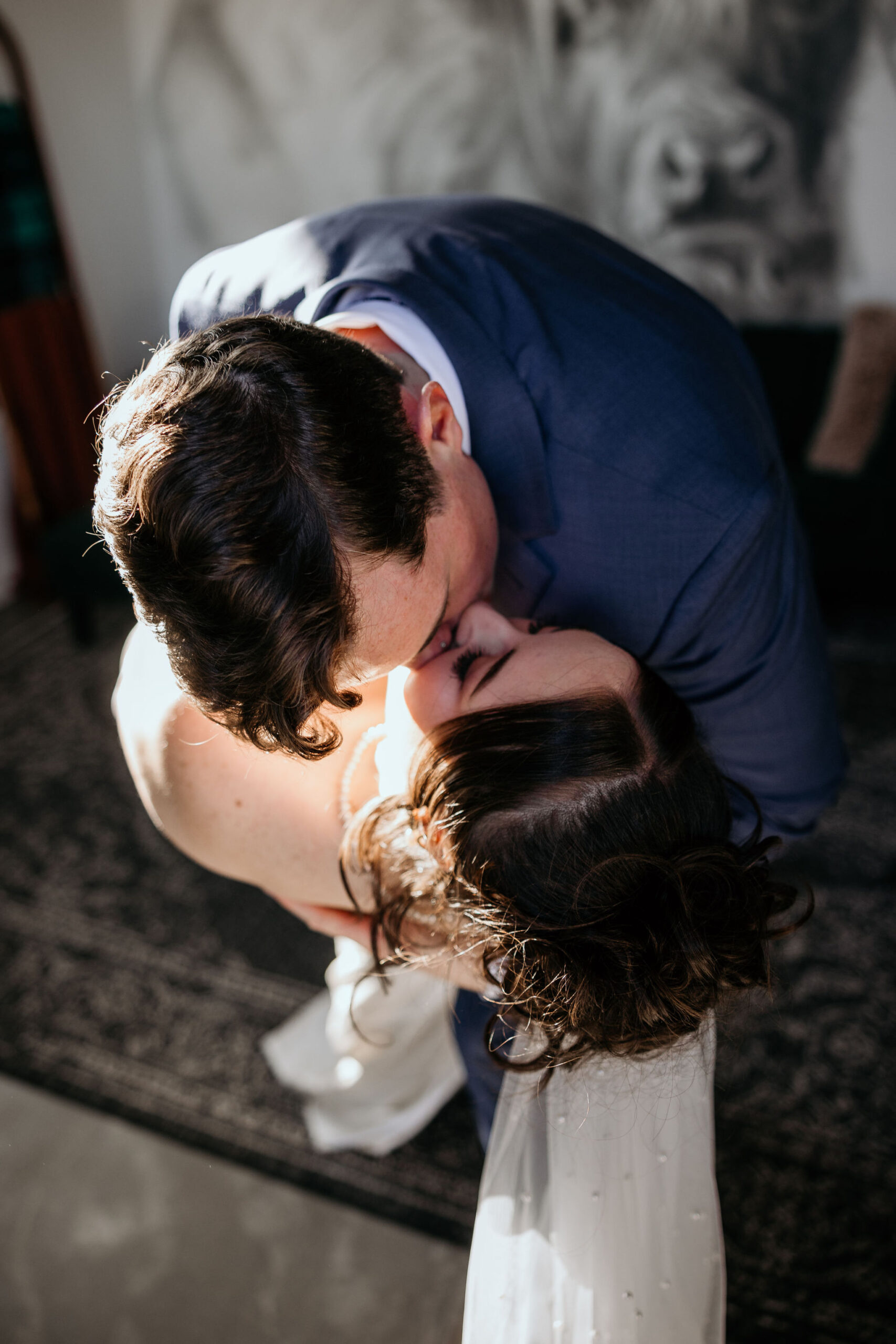 groom dips bride and kisses her during wedding first dance.