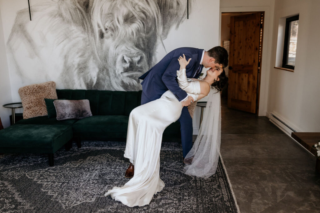 groom dips bride during wedding day first dance at colorado airbnb.