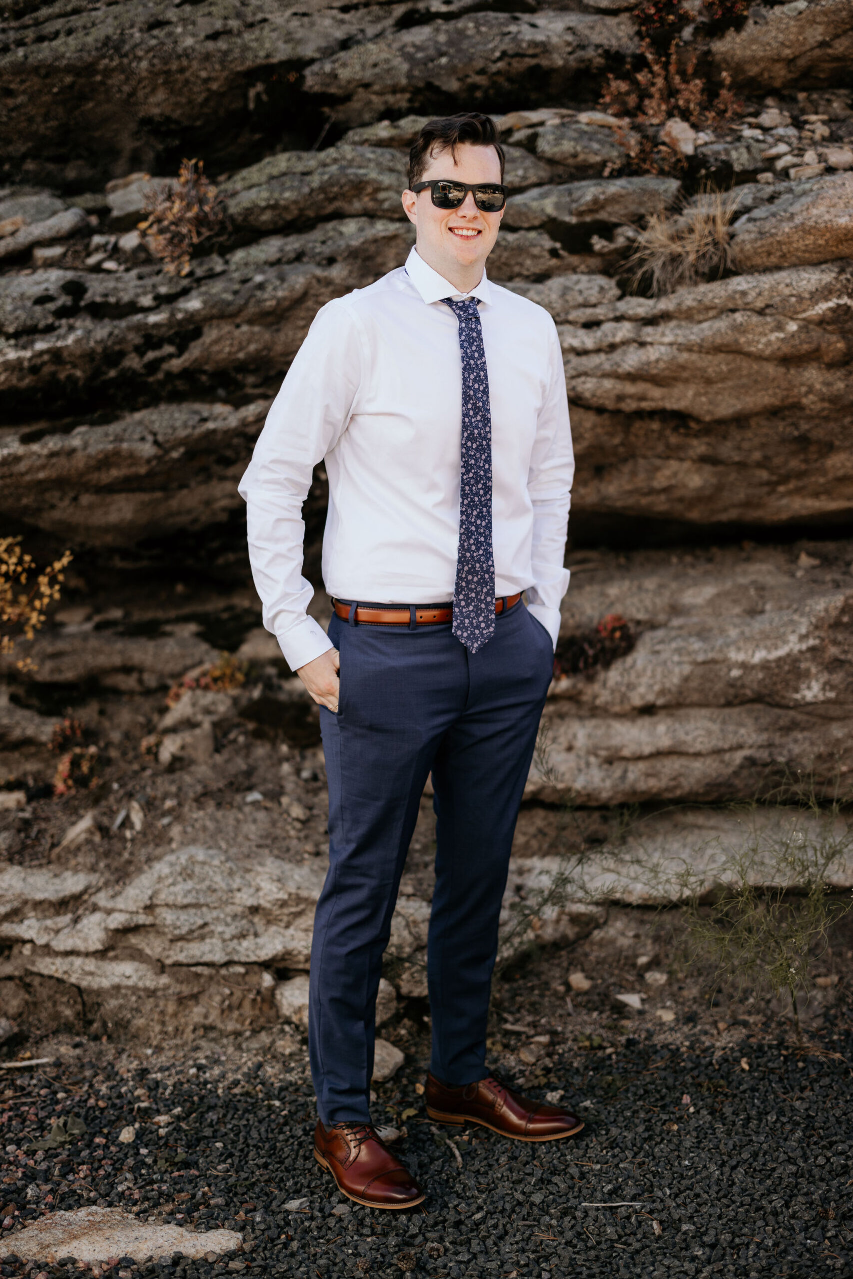 groom poses for colorado elopement photographer outside of airbnb.