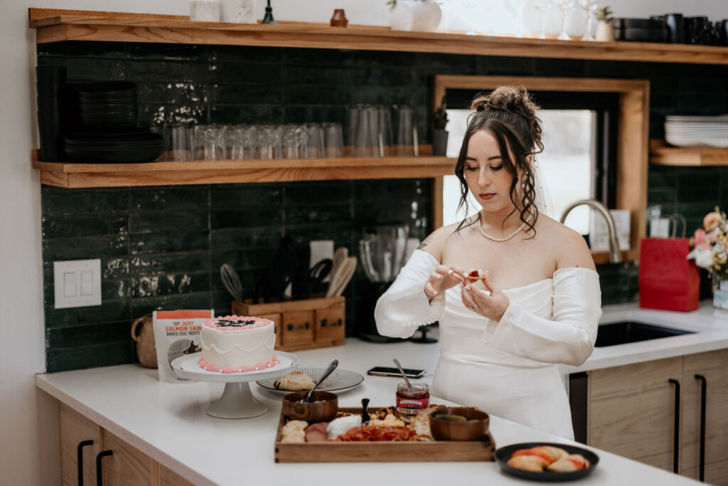 bride eats items from snack board during her colorado airbnb elopement.