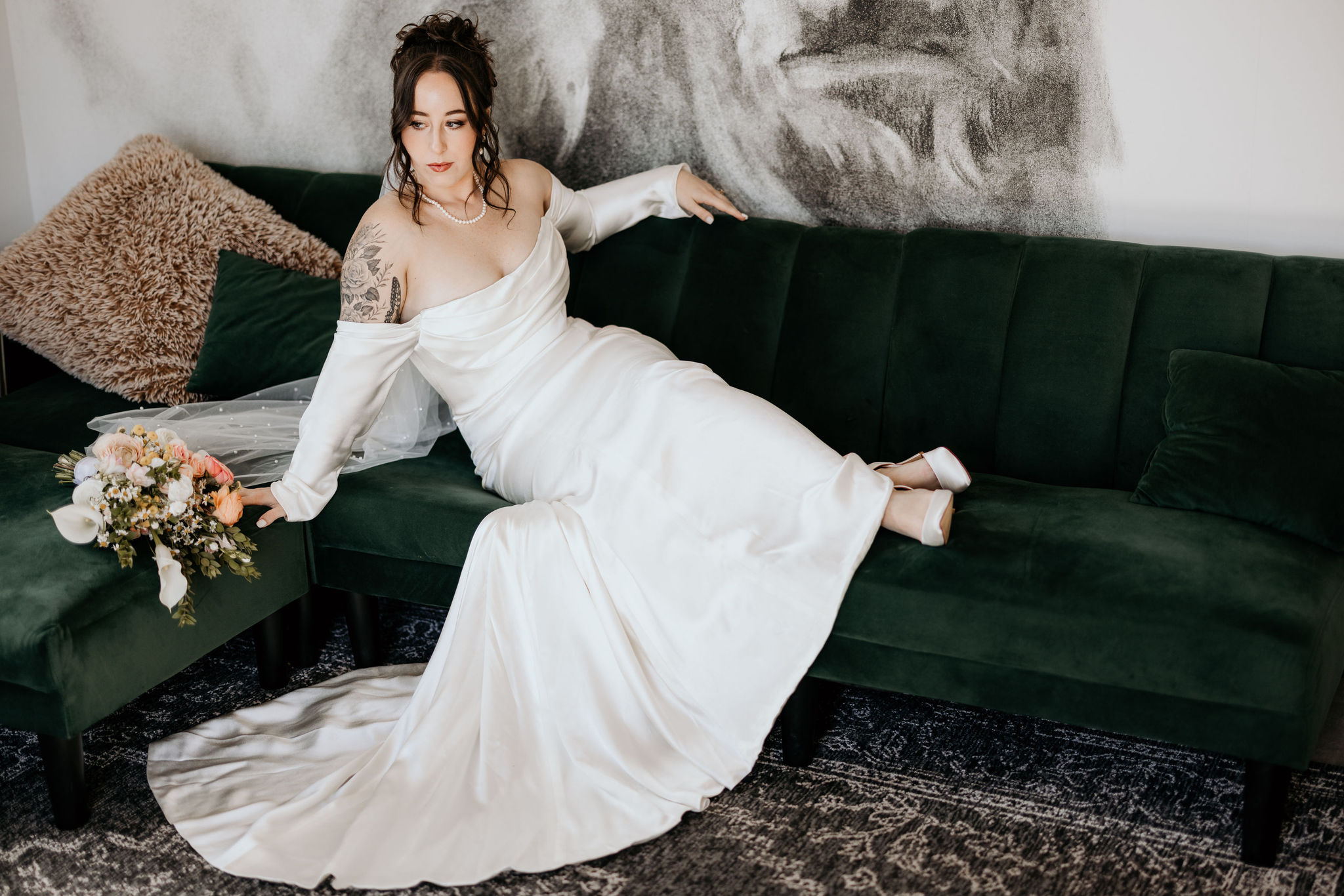 bride poses on green couch for colorado elopement photographer.