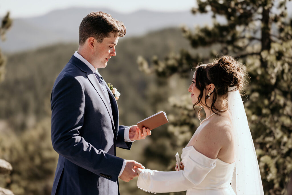 bride and groom read vows during colorado mountain elopement.
