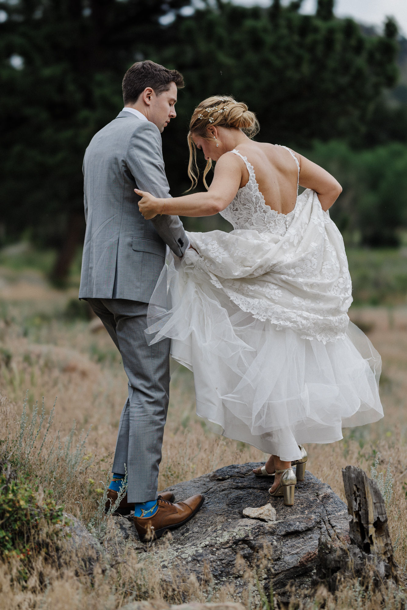 bride and groom stand on rock at national park