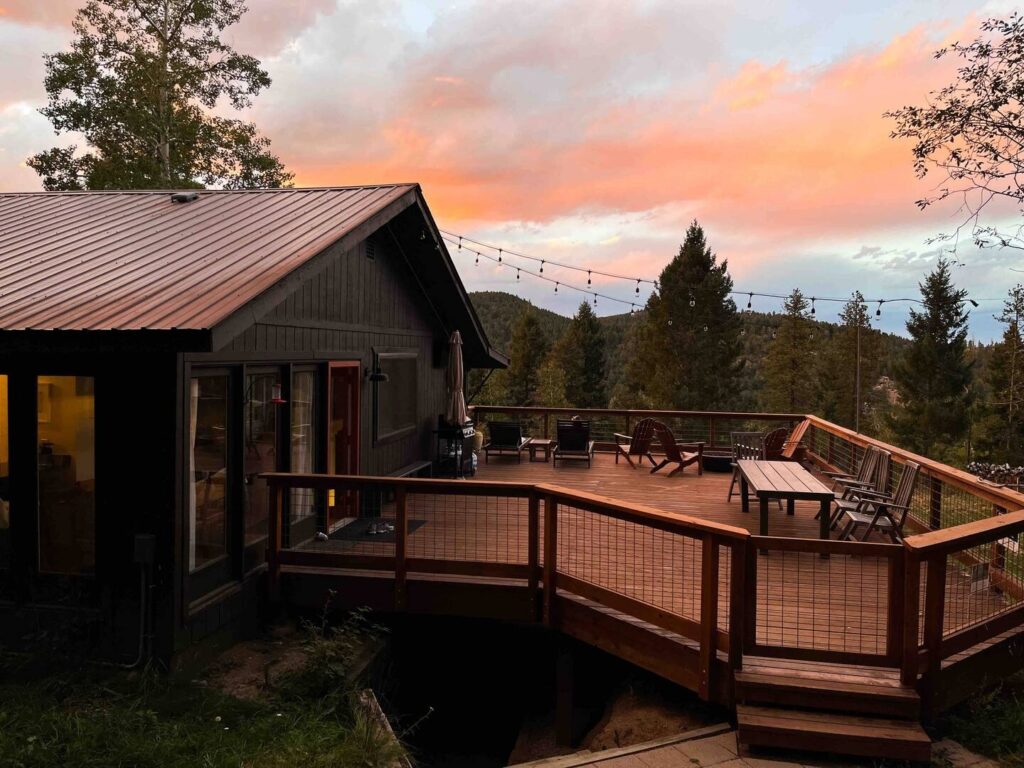house with large deck during sunset for a colorado airbnb micro wedding + elopement venue