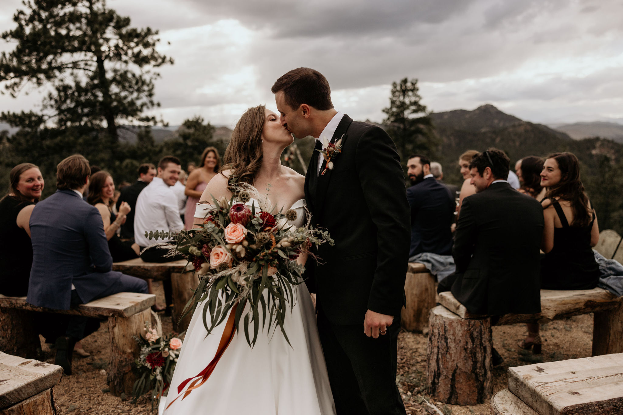 bride and groom kiss in the aisle during stress-free micro wedding in colorado.