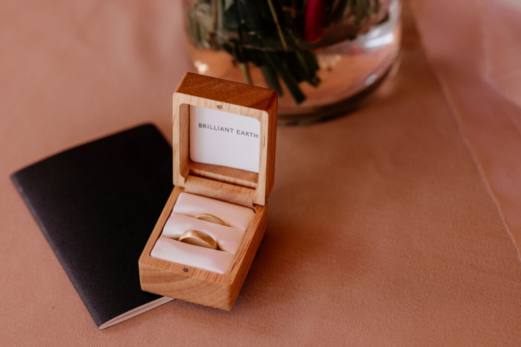 wedding rings sit on top of wedding vow book.