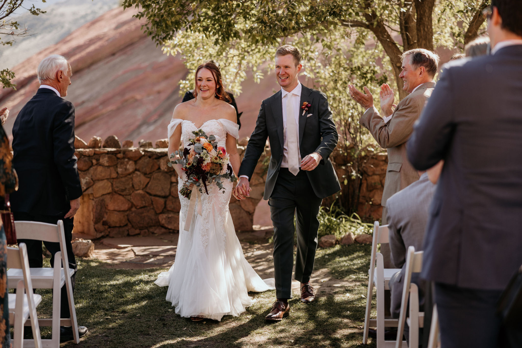 bride and groom walk down the aisle after micro wedding ceremony at red rocks.