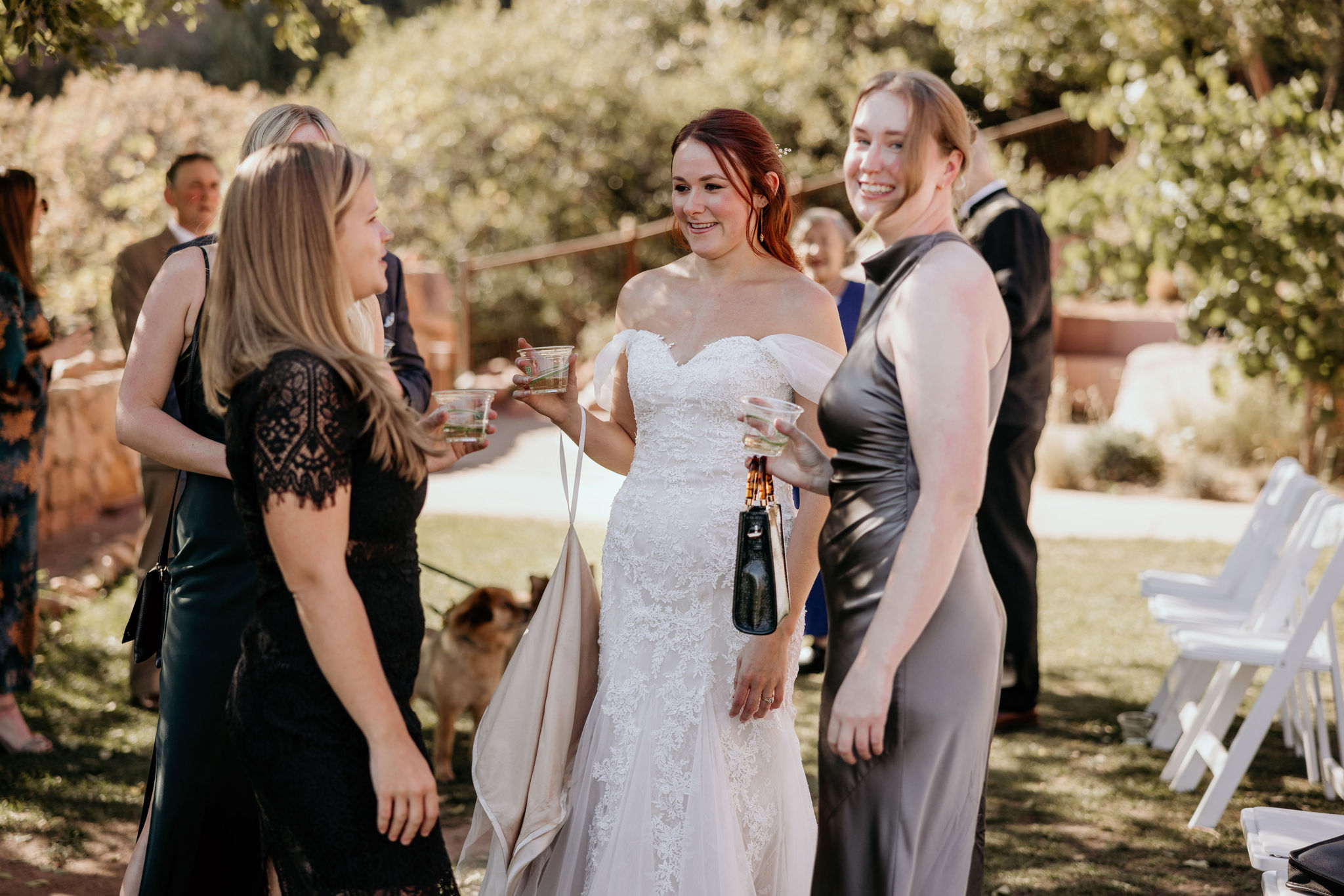 bride talks with friends during champgne hour after colorado wedding.