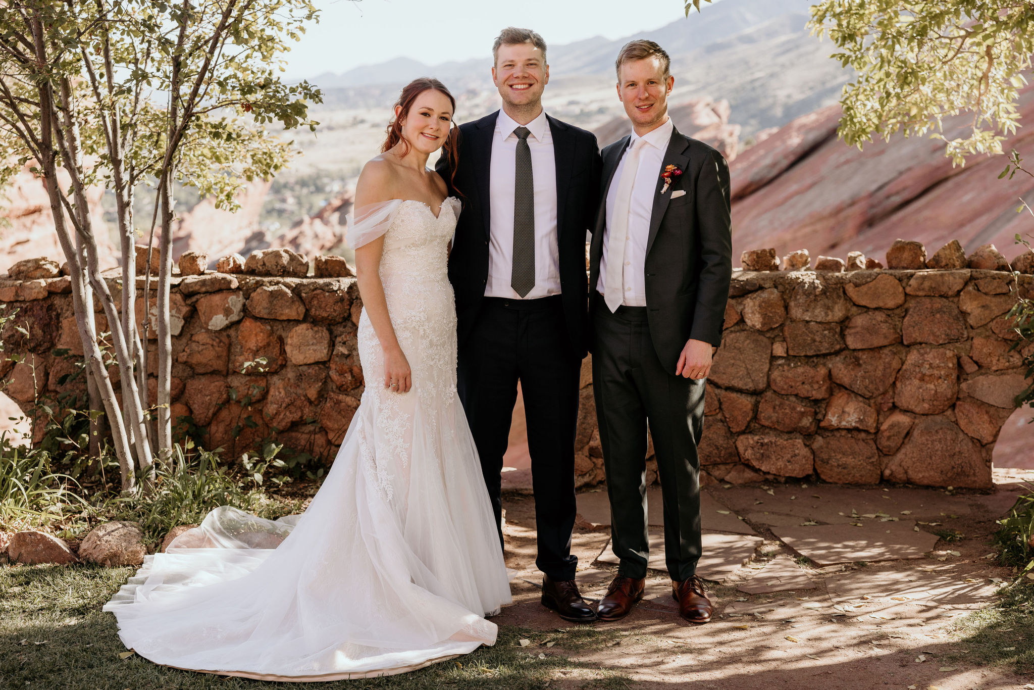 bride and groom pose with officiant for colorado micro wedding photographer.