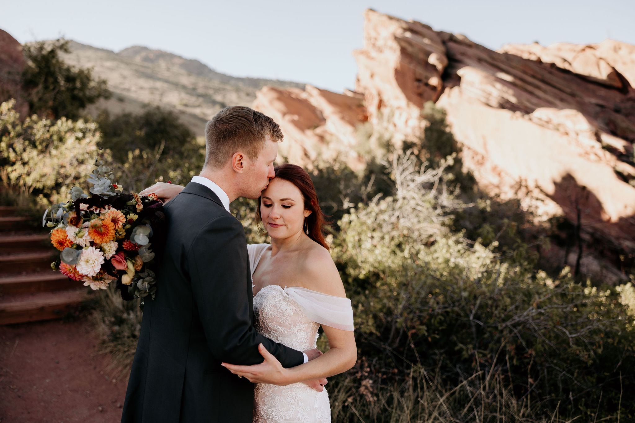 bride and groom embrace during their red rocks park and amphitheatre micro wedding.