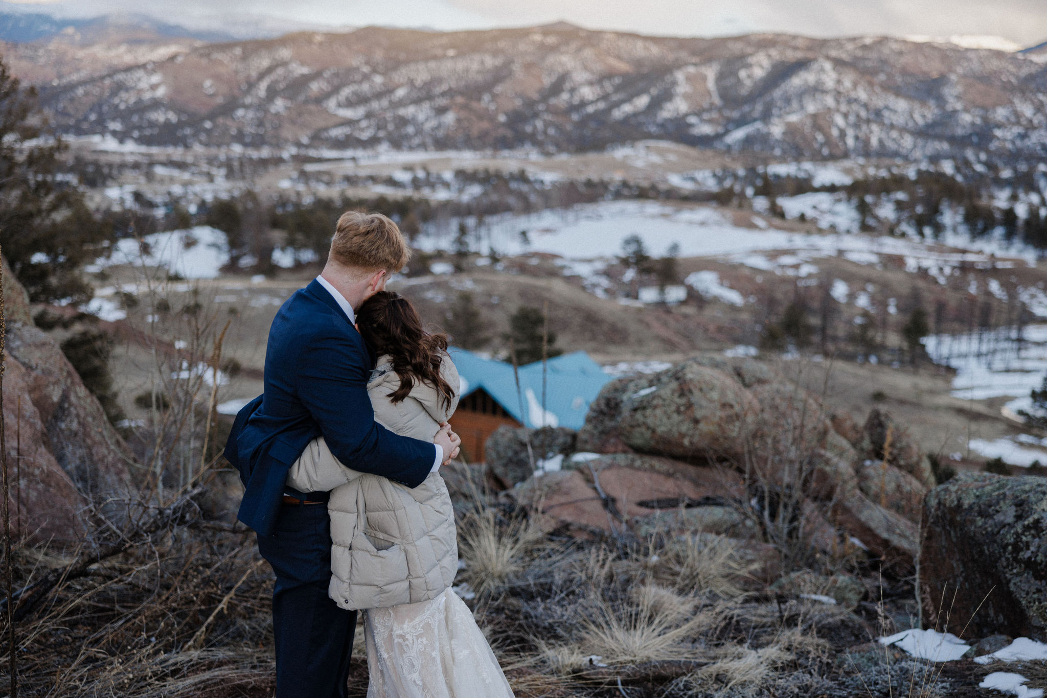 bride and groom hug and look down at colorado micro wedding airbnb venue