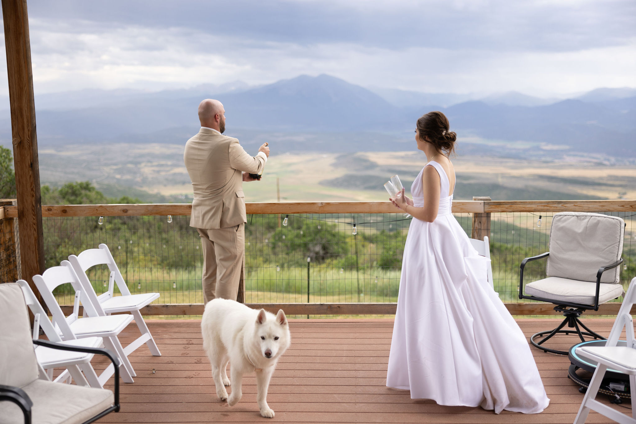 bride groom and dog stand on deck of colorado airbnb micro wedding + elopement venue