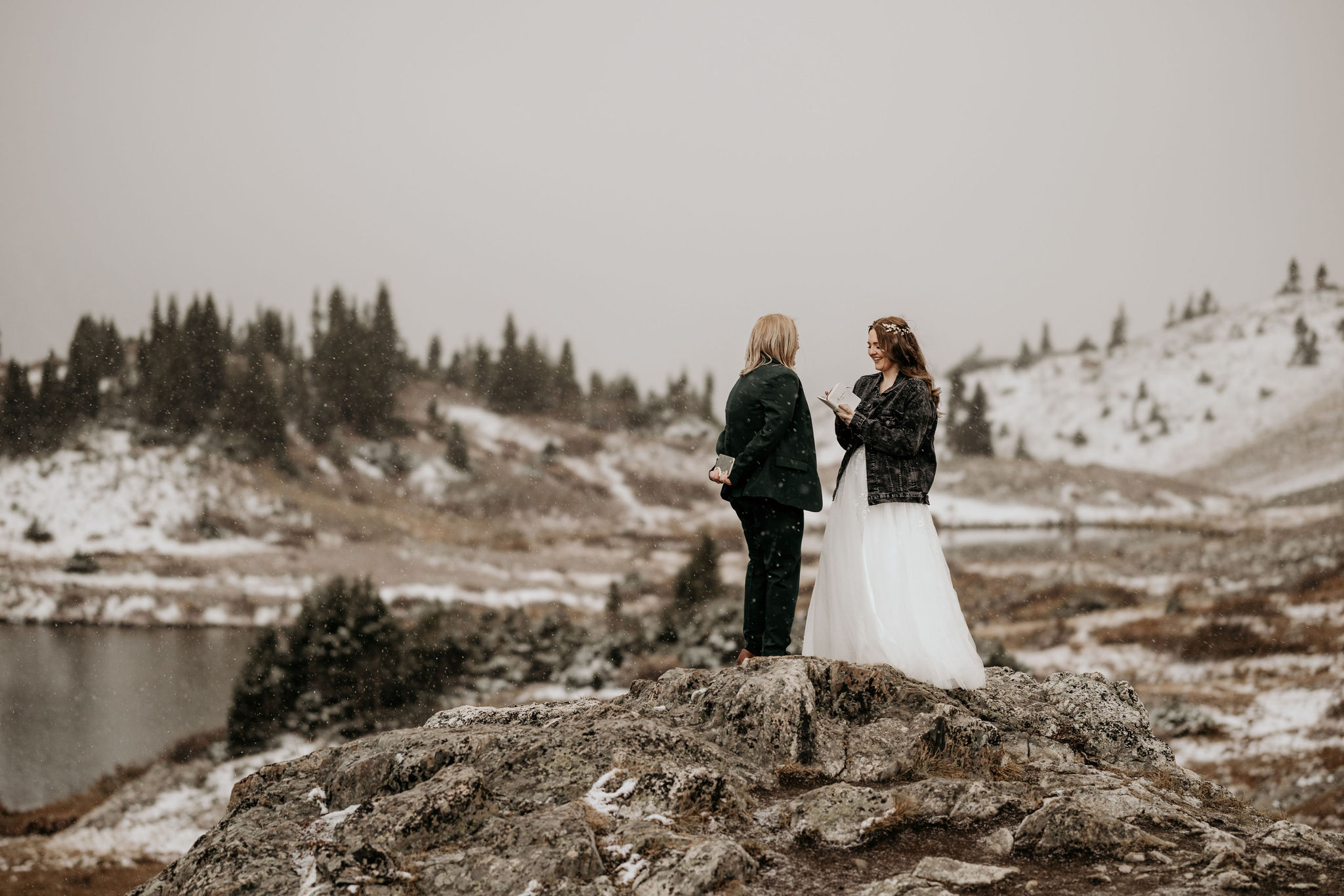 two brides stand on rock and say wedding vows during colorado elopement.