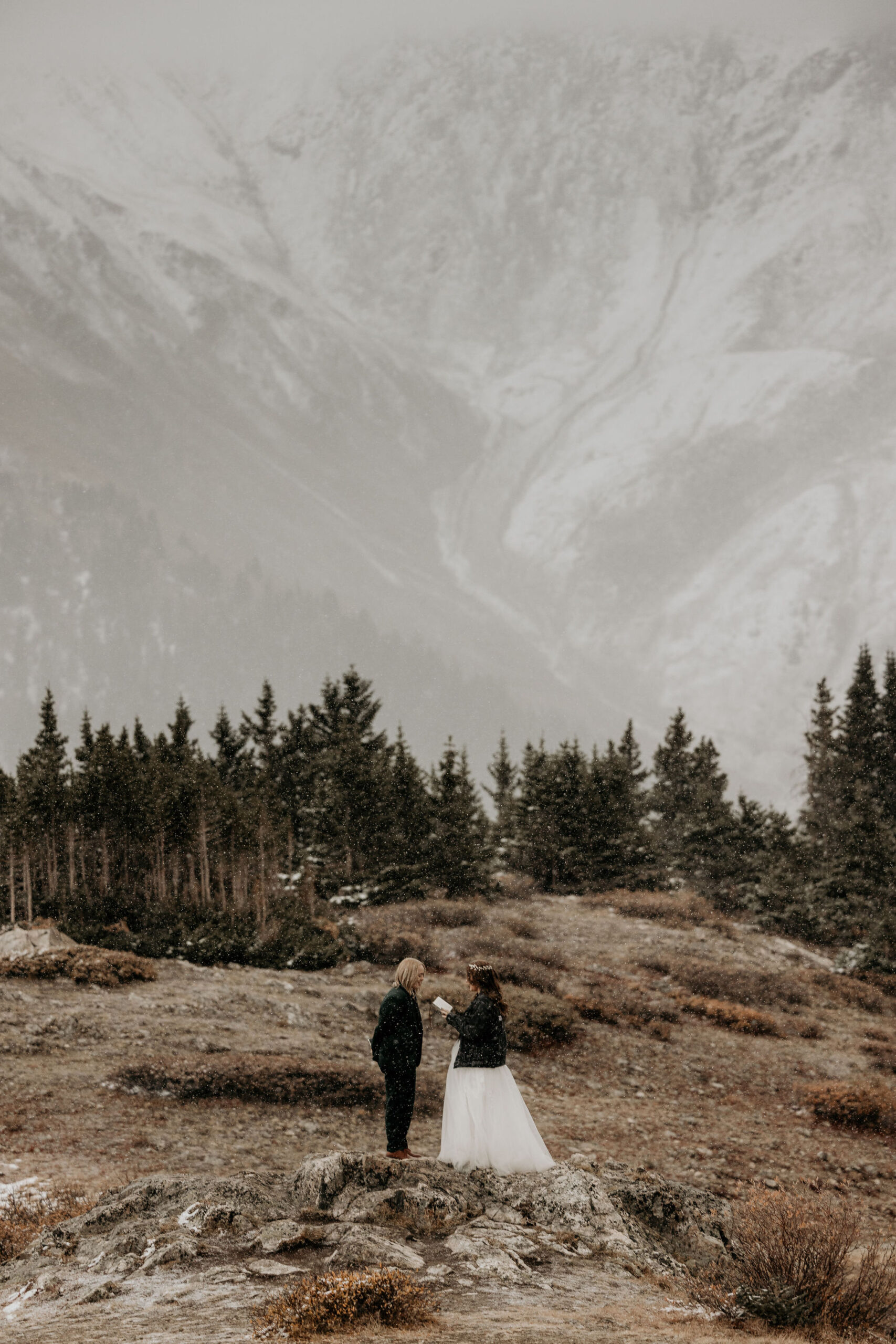 two brides say wedding vows during mountain elopement.