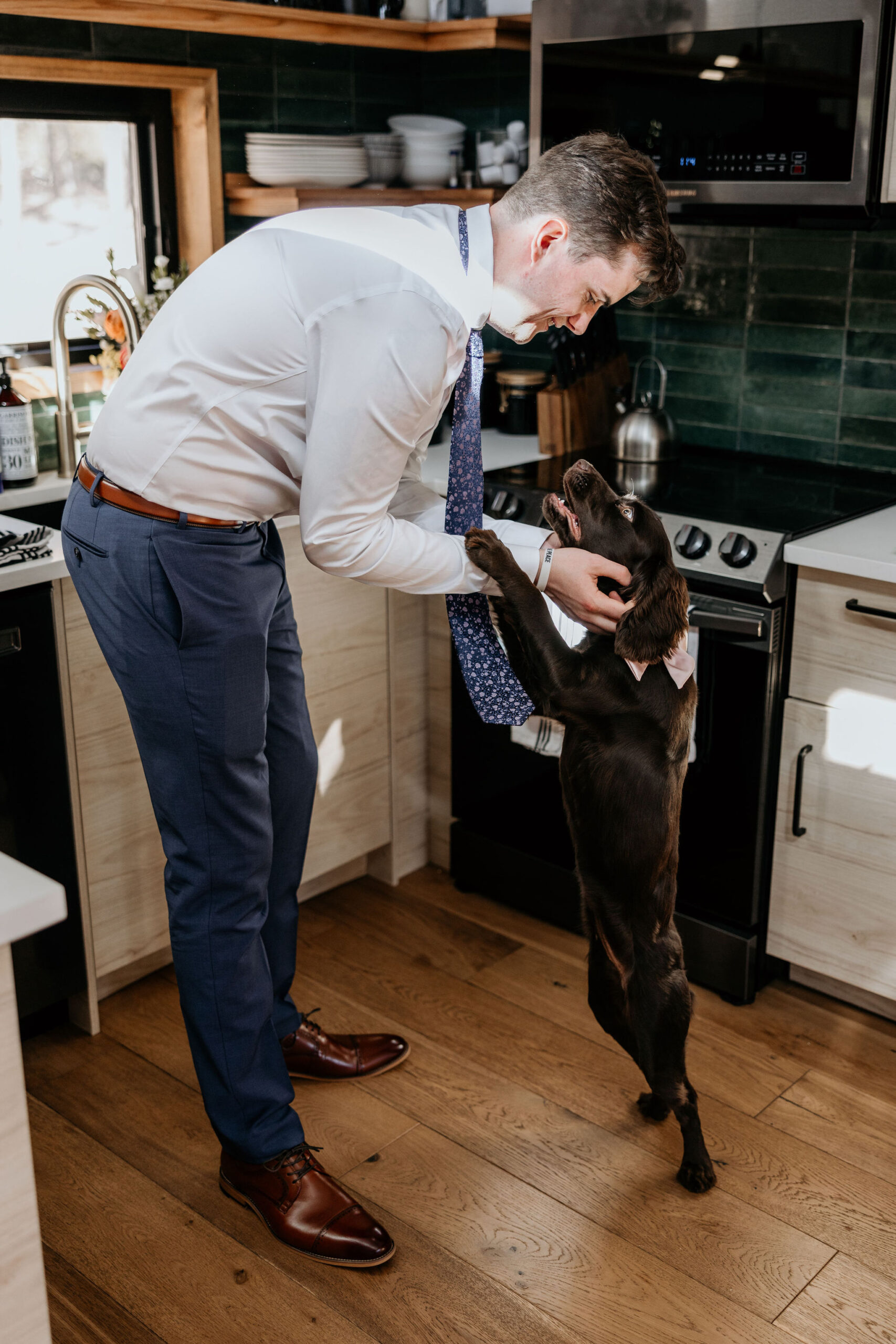 groom pets dog during airbnb elopement in the mountains