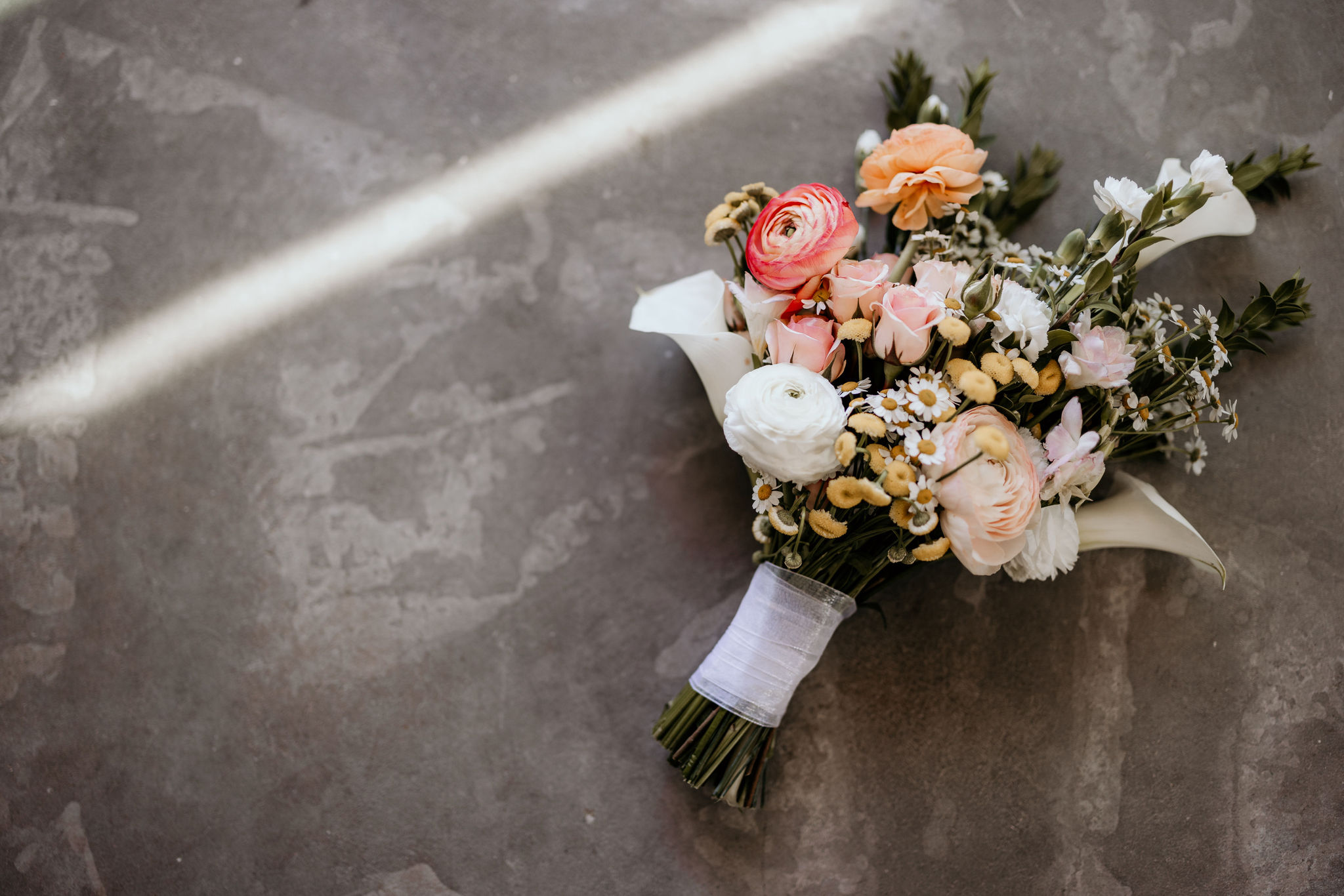 wedding bouquet, made by colorado vendor, sits on concrete.