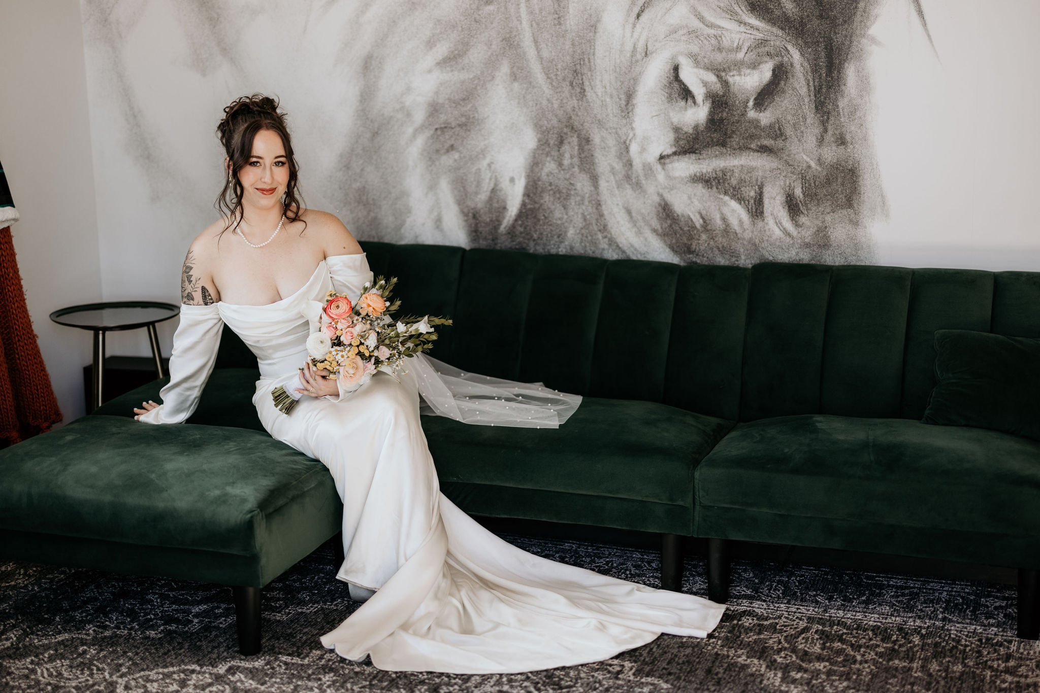 bride sits on green couch at colorado airbnb during airbnb wedding.