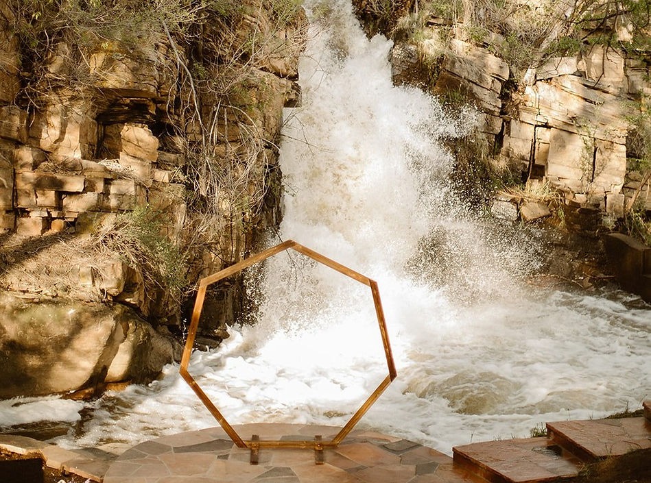 ceremony site in front of small waterfall at colorado airbnb rental estate for micro weddings and elopements