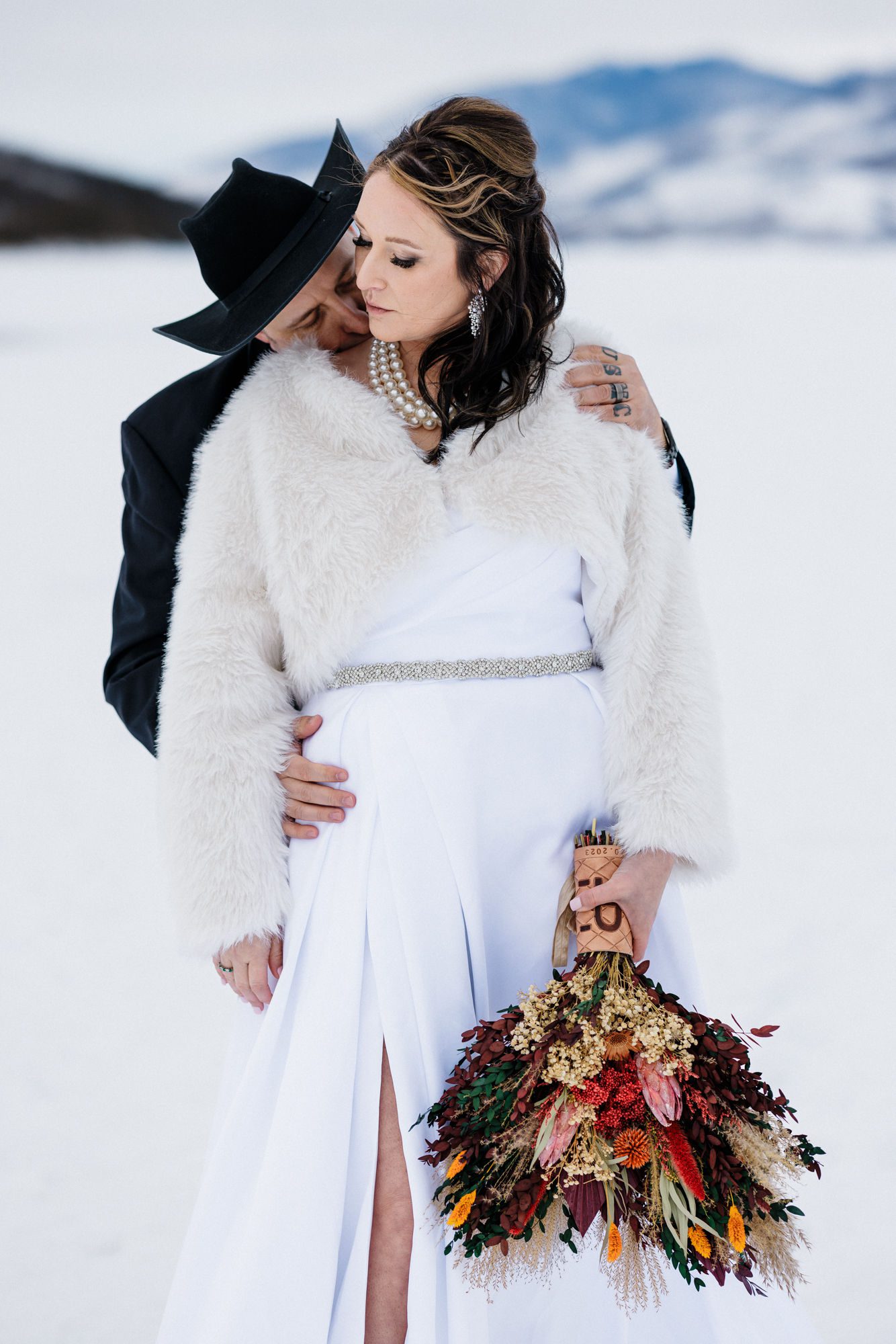 groom kisses brides shoulder during winter elopement in breckenridge, colorado