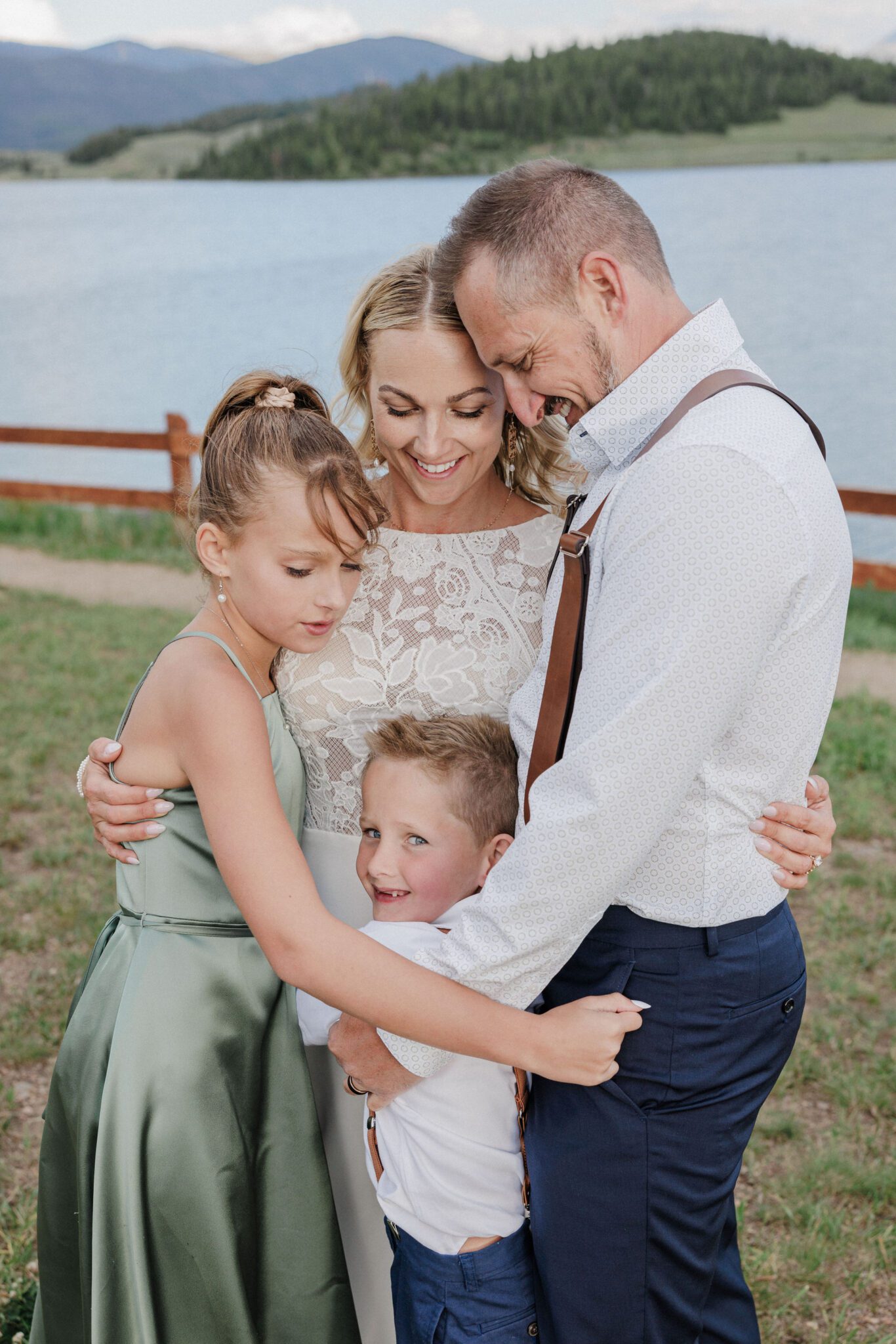 bride and groom hug their children after eloping with kids in colorado