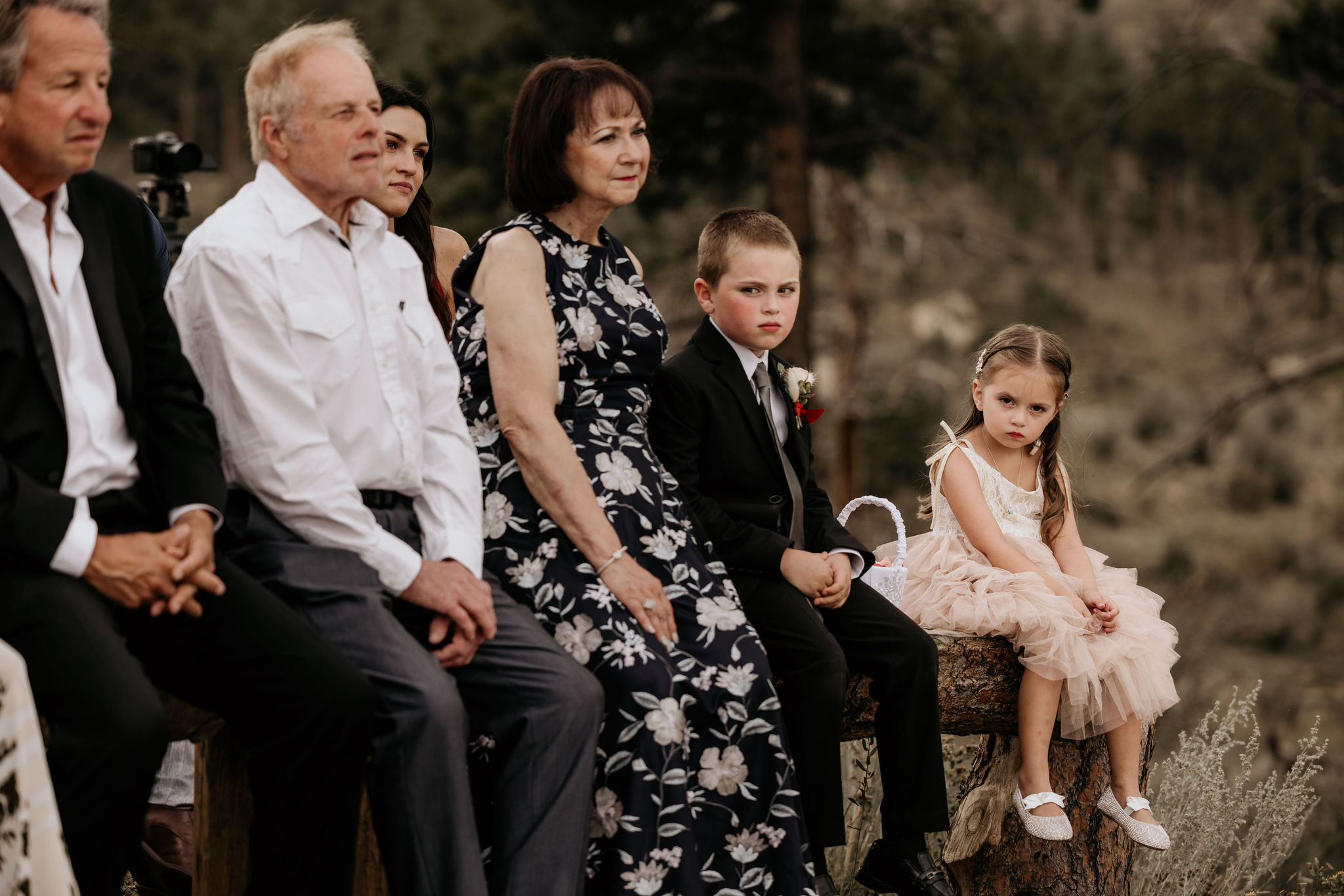 kids sit on a bench during a wedding ceremony