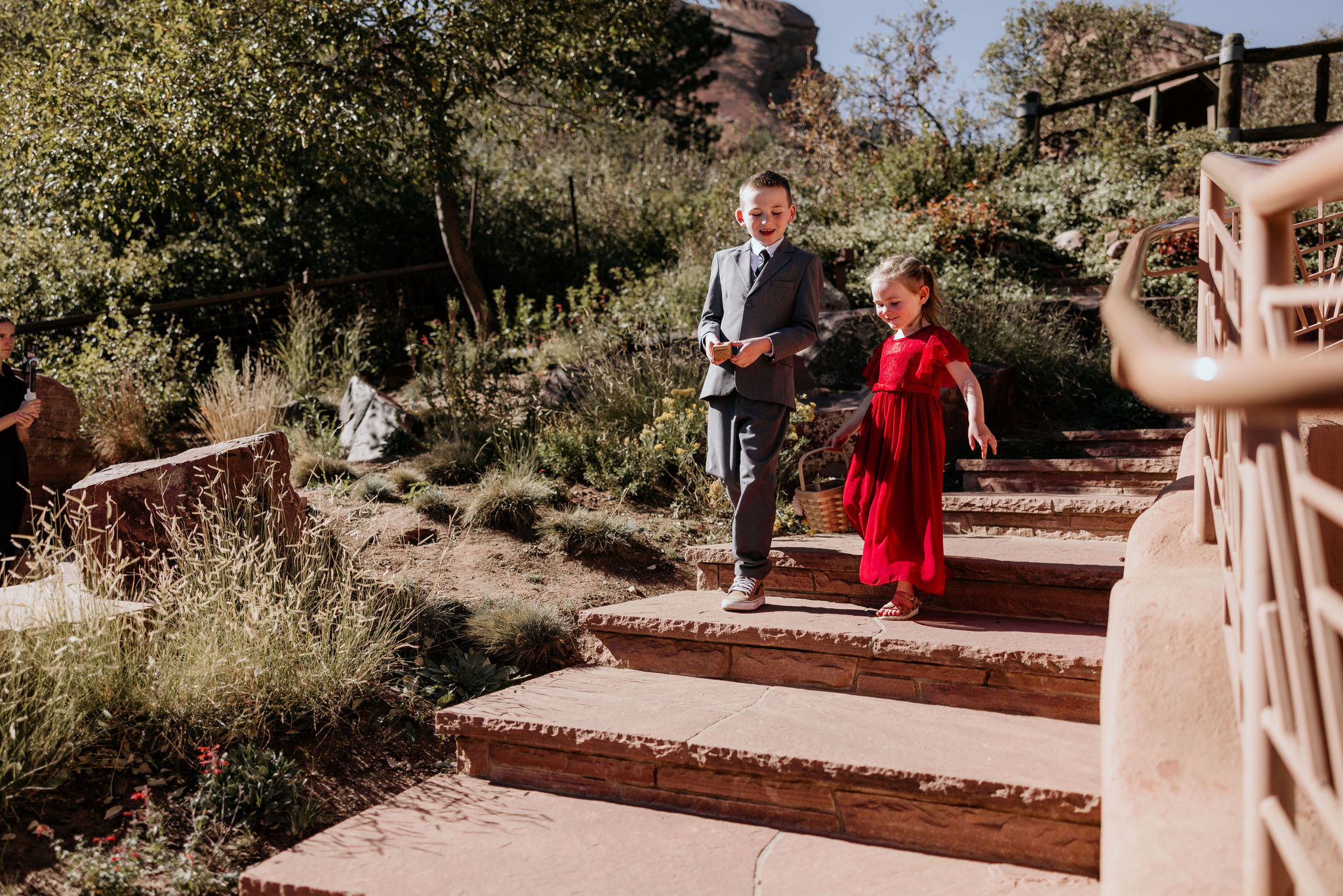 two little kids walk down aisle during colorado elopement day at red rocks.