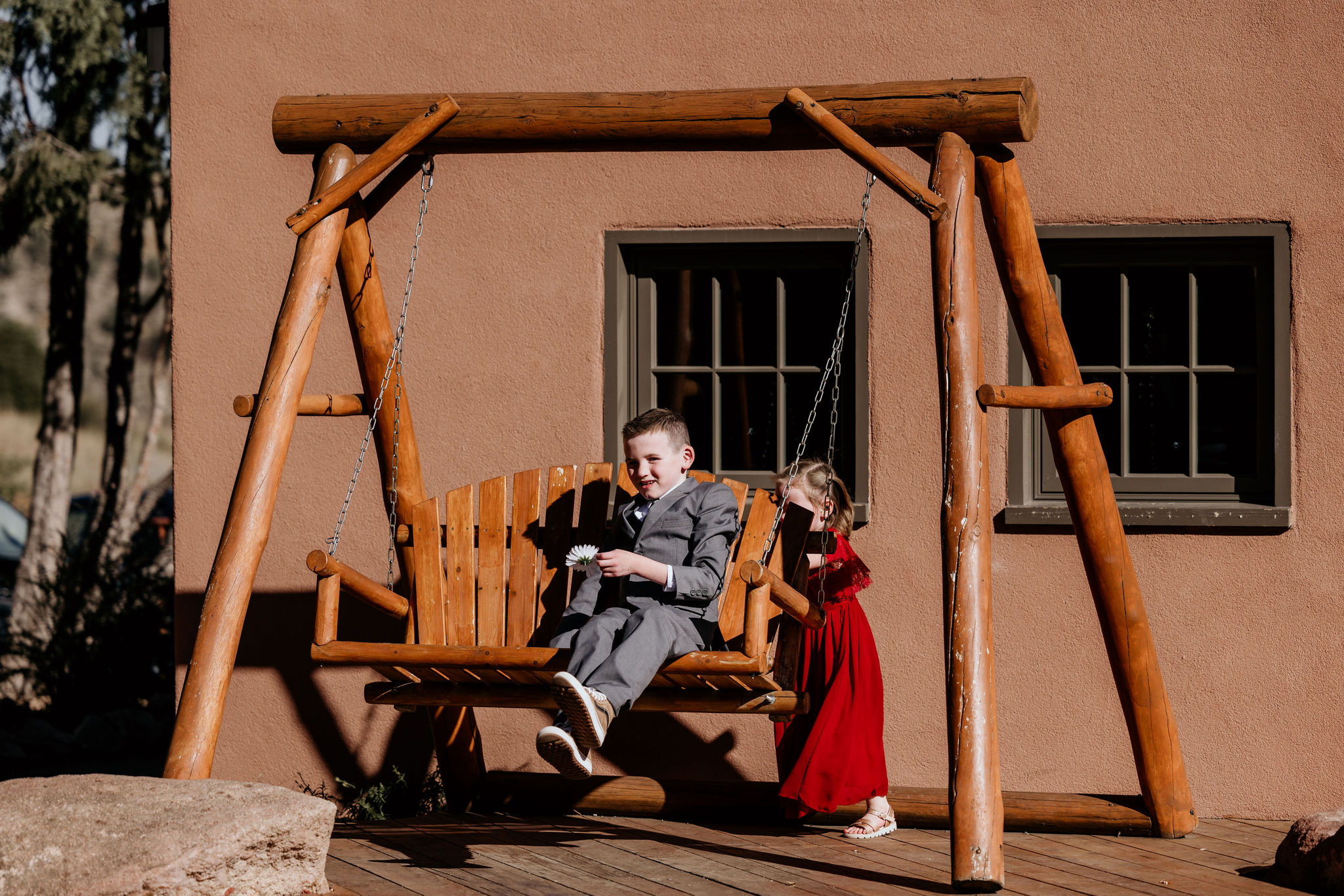 two kids play on a swing during elopement day