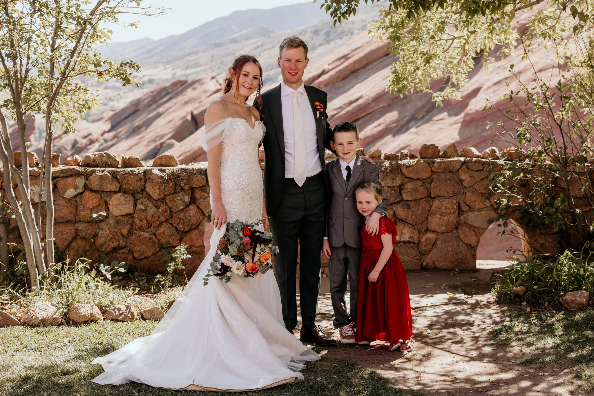 bride, groom, and kids pose for colorado micro wedding photographer during elopement at red rocks.
