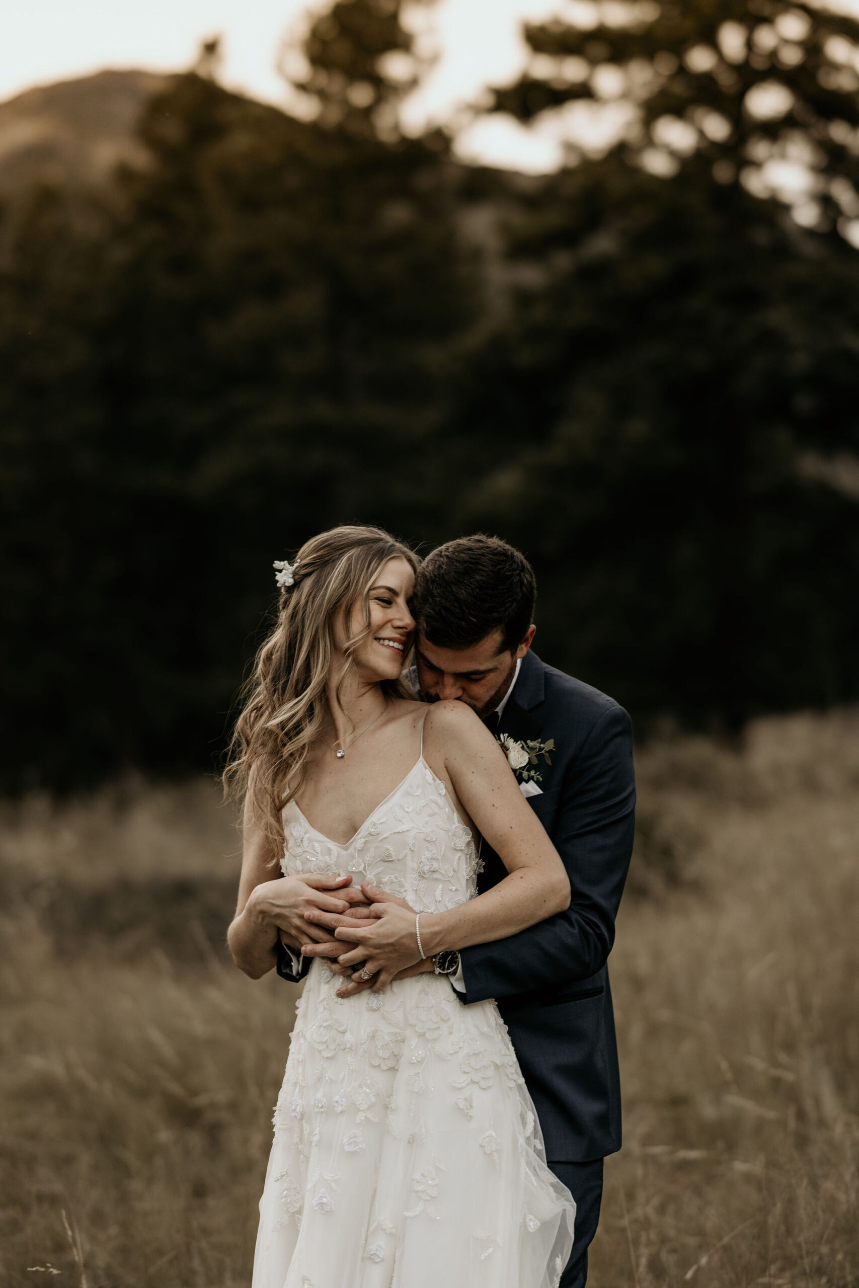 groom kisses brides shoulder during mountain elopement in colorado.
