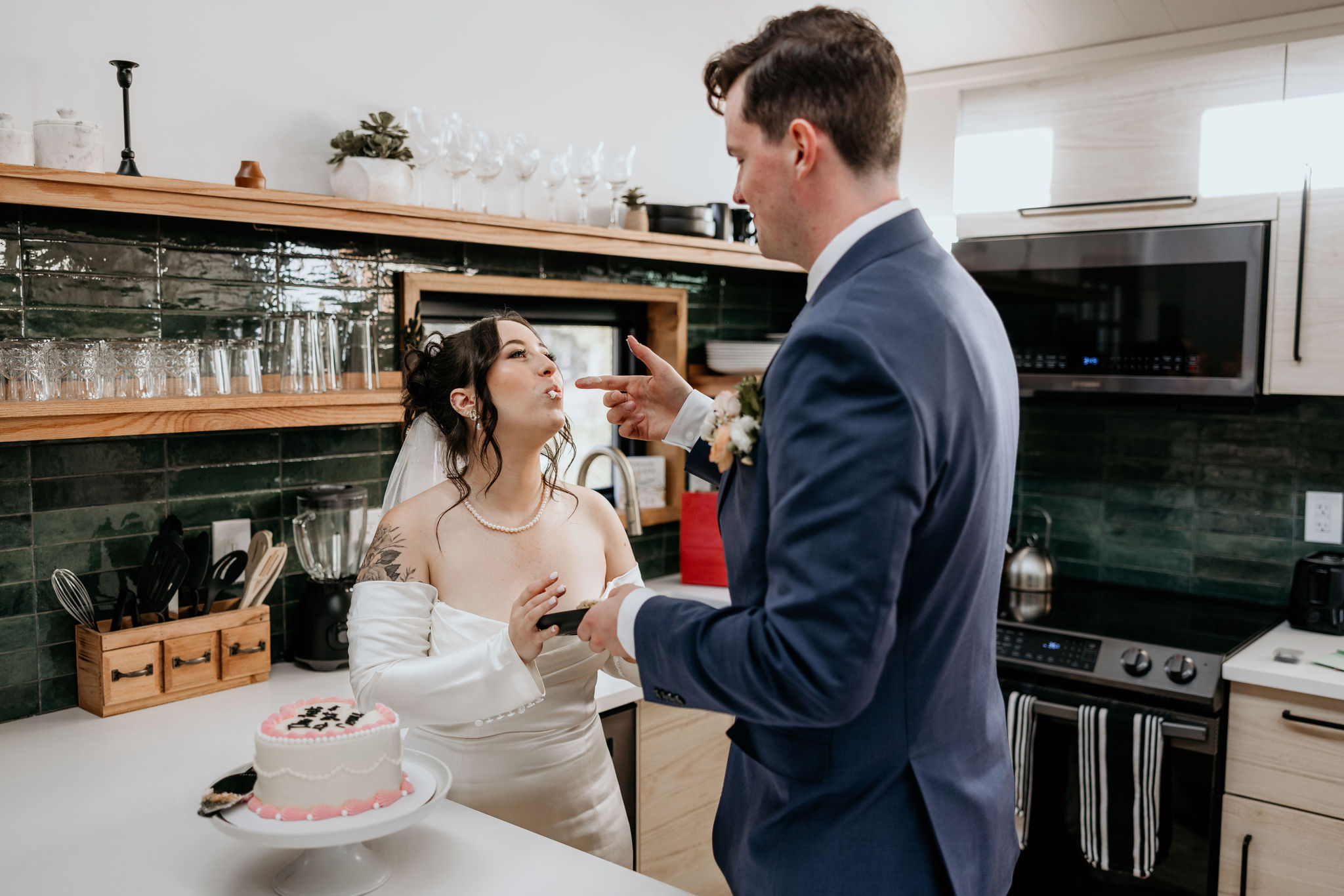 bride and groom eat wedding cake during winter elopement